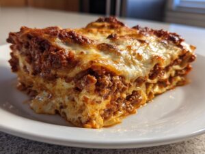 A generous, cheesy slice of easy lasagna with ricotta, showing layers of meat sauce and pasta.
