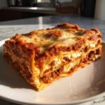 A thick, layered slice of Lasagna with Cottage Cheese featuring rich meat sauce and melted mozzarella, served on a white plate.