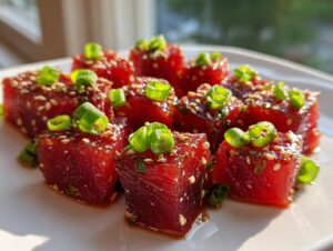 Close-up of perfectly cubed, marinated Tuna Tartare Recipe pieces garnished with sesame seeds and bright green scallions.