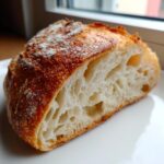 Close-up of a slice of amazing 1 hour Italian bread showing its airy, open crumb structure and golden crust.