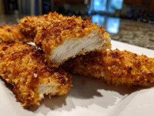 Close-up of perfectly cooked air fryer chicken tenders showing a crispy golden exterior and juicy white interior.