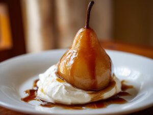 A beautifully glazed poached pear resting on a dollop of whipped cream, drizzled with rich syrup.