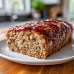 A close-up of a freshly baked stove top stuffing meatloaf topped with a thick layer of ketchup glaze.