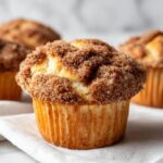 A close-up of an amazing coffee cake muffin topped generously with brown sugar cinnamon streusel.