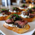 Close-up of perfectly cooked steak crostini topped with creamy cheese, caramelized onions, and fresh chives.