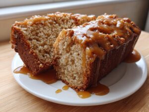 Two slices of moist apple dapple cake, generously topped with a rich caramel sauce dripping down the sides.
