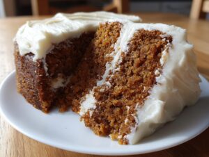 Close-up of a rich, dark brown slice of spice cake topped with thick white cream cheese frosting.