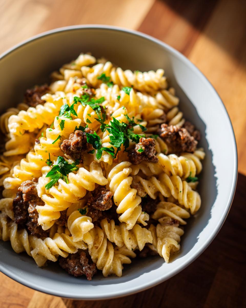 Close-up of one pot creamy beef and garlic pasta made with fusilli, topped with fresh parsley.