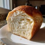 Close-up of the interior crumb of a freshly baked soft sourdough sandwich bread loaf.